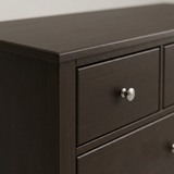 Close-up of wood grain and brushed nickel knob hardware
