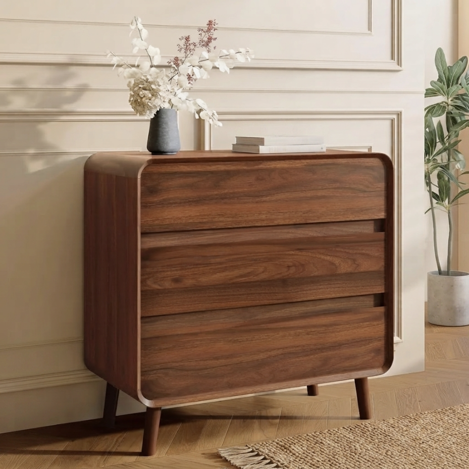 Curved walnut 3-drawer chest styled in a bedroom setting