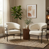 Two cream boucle barrel accent chairs shown together as a pair